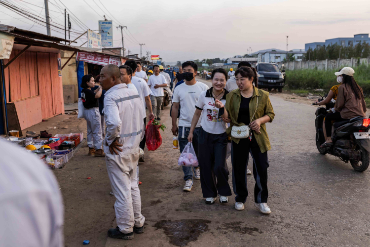 Chinese workers from PT Obsidian Stainless Steel who come to a makeshift market or to eat at the Chinese restaurant on the roadside in front of the smelter after their shift in Konawe Regency, Central Sulawesi, Indonesia on October 28, 2023.