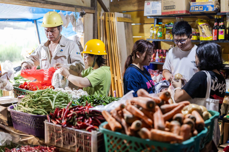 Chinese workers from PT Obsidian Stainless Steel who come to a makeshift market or to eat at the Chinese restaurant on the roadside in front of the smelter after their shift in Konawe Regency, Central Sulawesi, Indonesia on October 28, 2023.