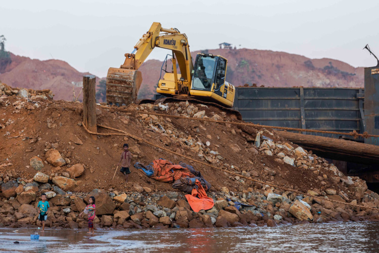 The children play near excavators while gathering soil containing nickel ore near the fishing villages of Mandiodo in Molawe district on October 27, 2023 in North Konawe, Southeast Sulawesi, Indonesia.