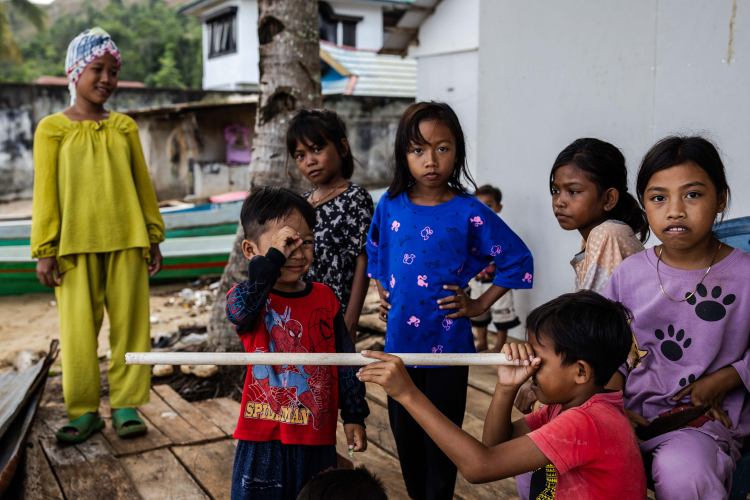 The children play near the sea waters contaminated by nickel mines at Mandiodo village near the nickel mining site on June 9, 2024, in North Konawe, Southeast Sulawesi, Indonesia.