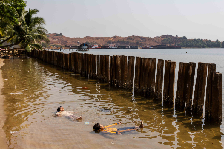 Aqifah, 8 (left), and Mitra, 9 swim in the polluted water at Mandiodo village near the nickel mining site on October 27, 2023 in North Konawe, Southeast Sulawesi, Indonesia.