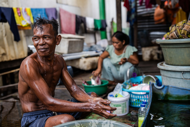 Bajau fishermen, Jusman bathes at his house in the fishing village of Kurisa near Indonesia Morowali Industrial Park (IMIP) on June 13, 2024, in Morowali, Central Sulawesi, Indonesia.