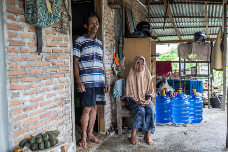 Sabit, 66 with his wife, Yayuk Jampiah, 58, poses for a photo outside his house in the villages of Bahomakmur on June 12, 2024 in Morowali, Central Sulawesi, Indonesia.