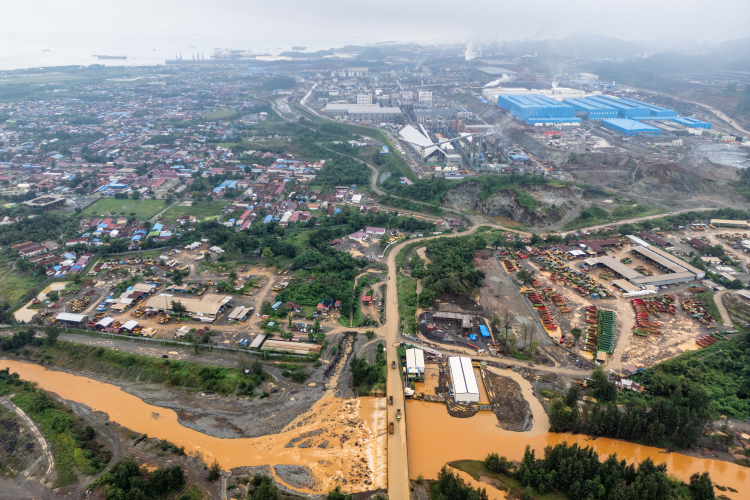 Trucks pass a bridge in an area of polluted water contaminated by nickel mine near of Indonesia Morowali Industrial Park (IMIP), a nickel processing complex in Morowali, Central Sulawesi, Indonesia on June 12, 2024.