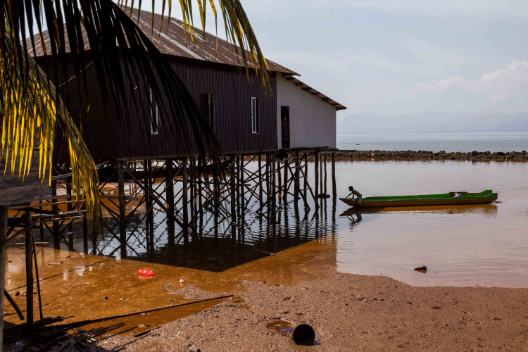 A boy who is in an area of sea waters contaminated by a nickel mine pulling the boat headed to his house at Mandiodo village on October 28, 2023 in North Konawe, Southeast Sulawesi, Indonesia.